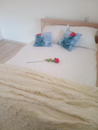 a white bed with blue pillows and a rose on it at Zaciszny zakątek pod Różą in Skawinki