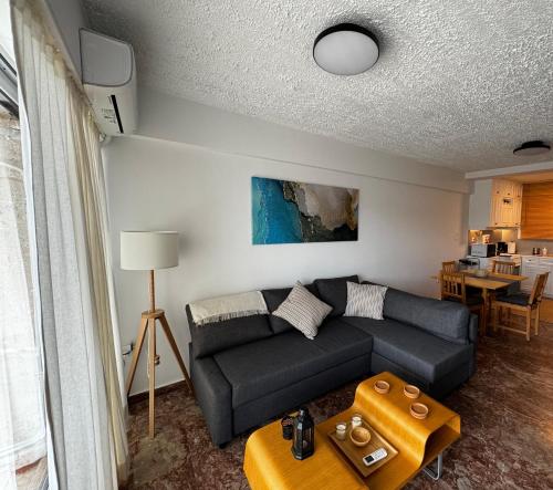 a living room with a couch and a table at Seashore Happiness Apartments in Porto Rafti