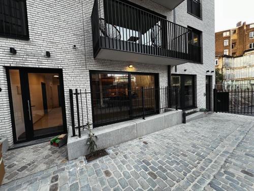 un bâtiment en briques avec un balcon au-dessus dans l'établissement T & B Trianon - Appartement Chic & Cosy, à Liège