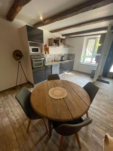 une cuisine avec une table et des chaises en bois dans l'établissement Maison de campagne avec jardin, à Viterne