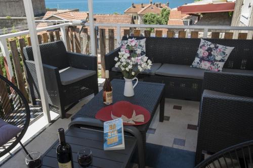 a patio with a couch and a table with flowers at Apartmani Zukic in Risan
