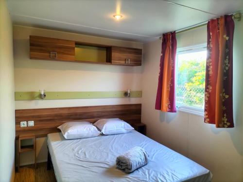 une chambre avec un lit et une fenêtre dans l'établissement Le mobil-home d'Amélie, entre mer et garrigue, à Vic-la-Gardiole