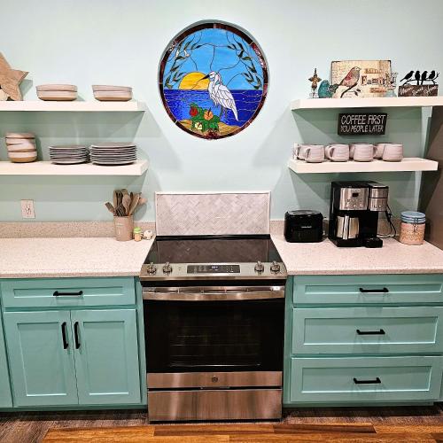 a kitchen with blue cabinets and a stove at Pat's Perch in Rockport