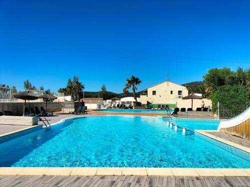 une grande piscine avec de l'eau bleue dans l'établissement Le mobil-home d'Amélie, entre mer et garrigue, à Vic-la-Gardiole