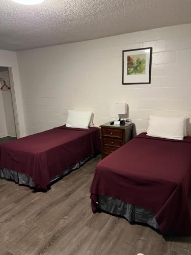 a hotel room with two beds and a dresser at Tip Top Motel in Lihue