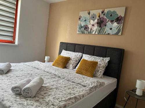 sypialnia z łóżkiem z żółtymi i białymi poduszkami w obiekcie kuća za odmor Domus Alba w mieście Branjin Vrh