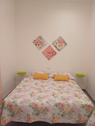 a bedroom with a bed with three pictures on the wall at Casa Vacanze Aversa centro 2 in Aversa