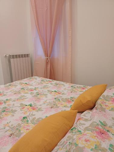 a bed with a floral bedspread and pillows on it at Casa Vacanze Aversa centro 2 in Aversa