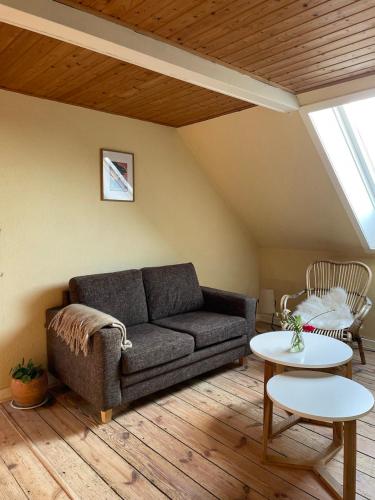 a living room with a couch and a table at Homestay in charming house on the countryside in Rønne