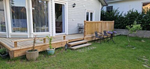 a wooden deck with a table and chairs on a yard at Sjöviksvilla Sjöviksvägen in Växjö