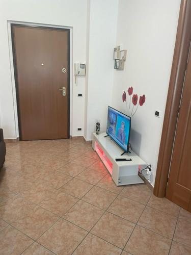 a living room with a tv on a table in a room at NORA House in Savona