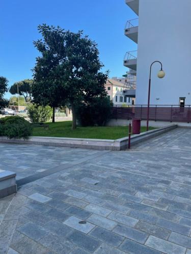 an empty parking lot with a tree and a building at NORA House in Savona