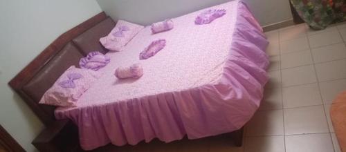 ein violettes Bett mit lila Bettlaken und lila Kissen in der Unterkunft Résidence la Grâce Benkadi in Bobo-Dioulasso
