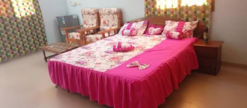 ein Schlafzimmer mit einem rosa Bett mit einer rosa Tagesdecke in der Unterkunft Résidence la Grâce Benkadi in Bobo-Dioulasso