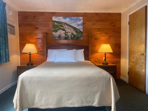 a bedroom with a large bed with two lamps at Lake Crest Inn in Lake George