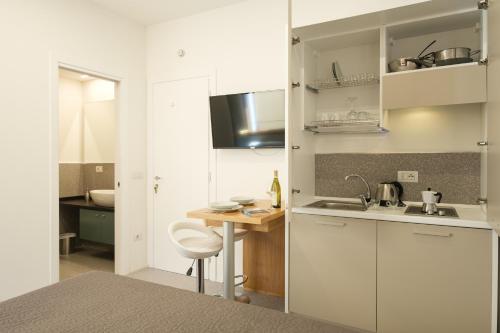 a kitchen with white cabinets and a wooden table at Studio apartment in the Castle Castelsardo in Castelsardo