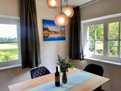 een eetkamer met een tafel en twee ramen bij Appartements Wieseneck - beste Lage inklusive Sommercard in Ramsau am Dachstein