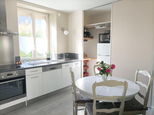 une cuisine avec une table et des chaises et une fenêtre dans l'établissement Maison tout confort proche Chambord, à Villorceau