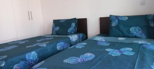 two beds with blue comforters with butterflies on them at Trendy Holiday Villa 34 Larnaca, Pyla in Pyla