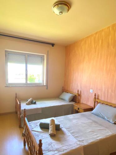 1 dormitorio con 2 camas y ventana en A casa da Sia, en Ribadeo