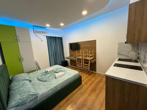 1 dormitorio con 1 cama y cocina con fregadero en Suite Rana Hedhun, en Shëngjin