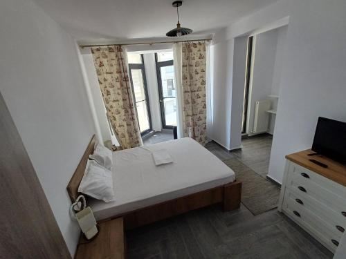 1 dormitorio con 1 cama y TV en Apartament RAMI Mamaia Nord, en Mamaia Nord – Năvodari