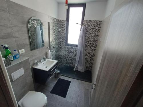 a bathroom with a shower and a toilet and a sink at Apartament RAMI Mamaia Nord in Mamaia Nord