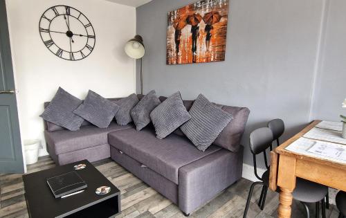 a living room with a couch and a clock on the wall at The Penthouse NY Loft Apartment in Barmouth