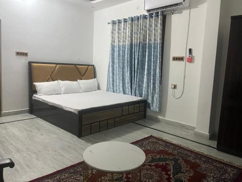 een kleine kamer met een bed en een tafel bij Shri Ram International Home Stay Ayodhya in Ayodhya