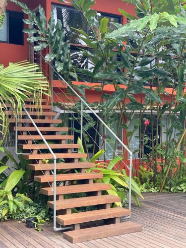 a wooden staircase in a garden with plants at Flat Camburi in Camburi