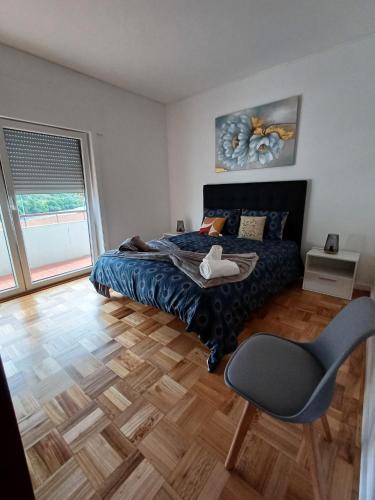 a bedroom with a bed and a chair and a window at Pinhão House in Pinhão