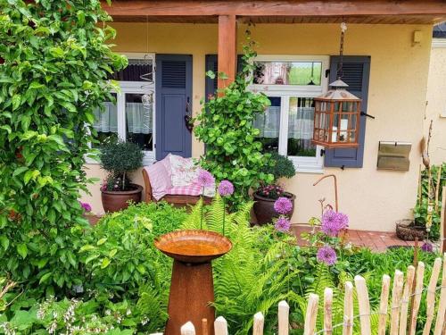 a garden with a bird bath in front of a house at Frankenwaldhaus Comfortable holiday residence in Wilhelmsthal