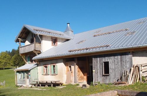 an old house with a metal roof on a field at La Petite Echelle in Rochejean
