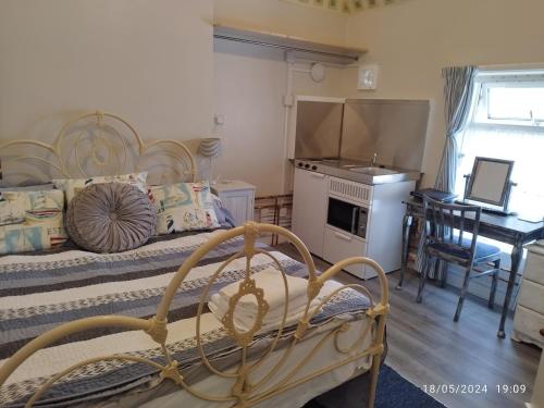 1 dormitorio con 2 camas y cocina con mesa en Blue Palms, en Bournemouth
