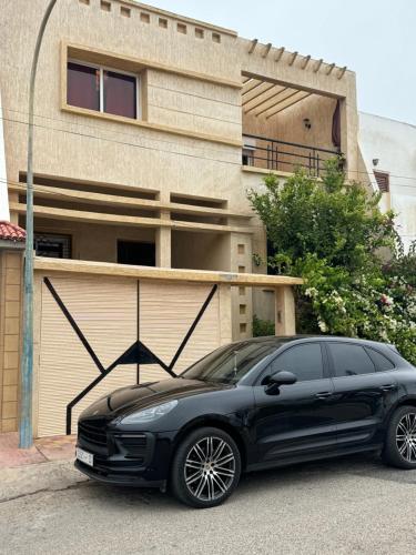 a black car parked in front of a house at Superbe Villa Face à l'Ocean - Agadir beach City in Agadir