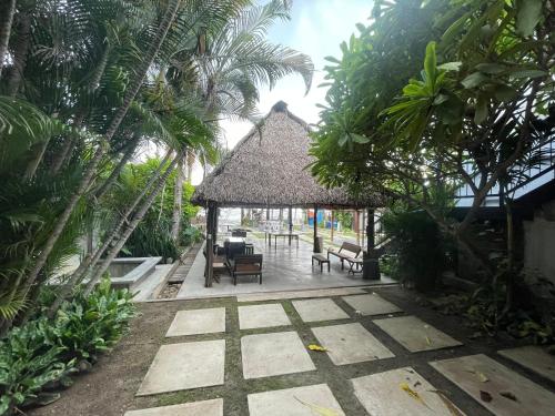 einen Pavillon mit Stühlen, Tischen und Palmen in der Unterkunft San Carlos Surf Resort & Eco Lodge in San Carlos