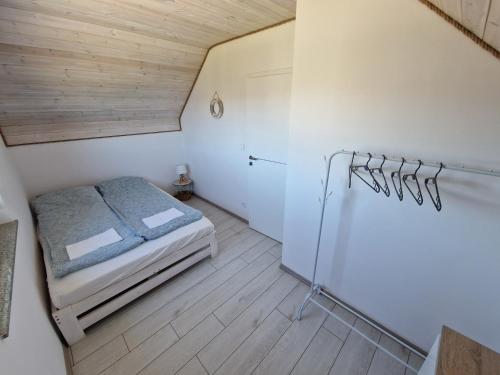 Dormitorio pequeño con cama en el ático en Domki Rajski Wypoczynek z basenem en Jastrzębia Góra