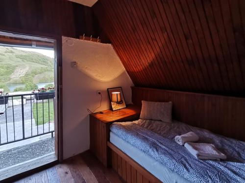 Habitación pequeña con cama y balcón. en Vikendica na jezeru, en Gacko