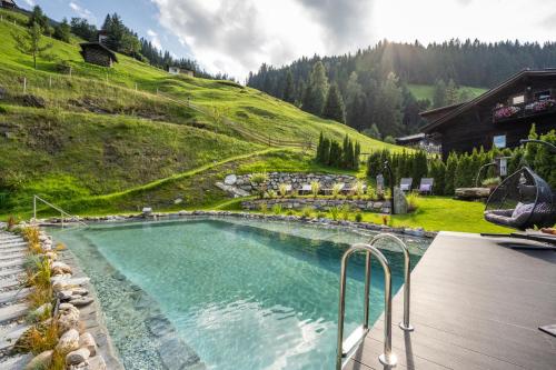 a swimming pool in the middle of a mountain at Naturhotel Hüttenwirt im Grossarltal in Hüttschlag