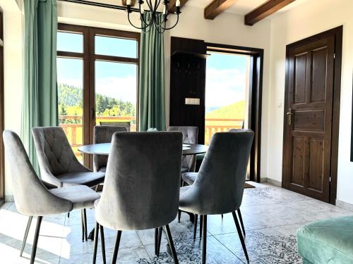 a dining room with a table and chairs at Apartamenty Wilcza Knieja in Zawóz
