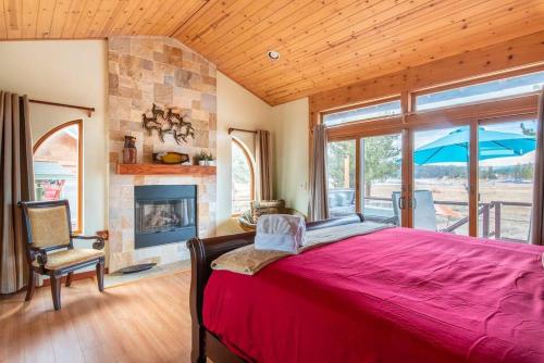 a bedroom with a large bed and a fireplace at Lake Time Villa NEW Luxury with HOT TUB in Big Bear Lake
