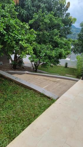 a walkway with trees and a lake in the background at Casa de descanso urbana in Villeta
