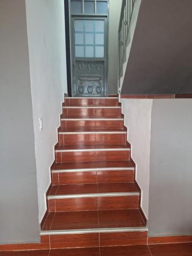 a stairway with a glass door and wooden stairs at Casa de descanso urbana in Villeta