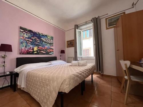 a bedroom with a bed and a painting on the wall at Althea Rooms in Florence