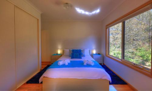 a bedroom with a large bed and a window at Roosters Rest in Port Sorell