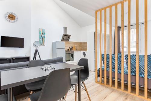 une chambre avec un lit, une table et des chaises dans l'établissement Dominici 5 CahorsCityStay, à Cahors