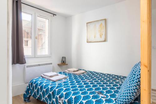 une chambre avec un lit avec une couette bleue et une fenêtre dans l'établissement Dominici 5 CahorsCityStay, à Cahors
