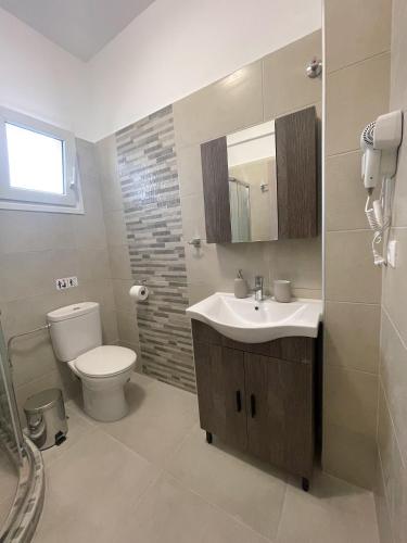 a bathroom with a sink and a toilet at Armonia Guest House in Nea Roda