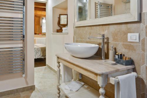 un bagno con lavandino bianco su un bancone in legno di Da Titta a Pitigliano