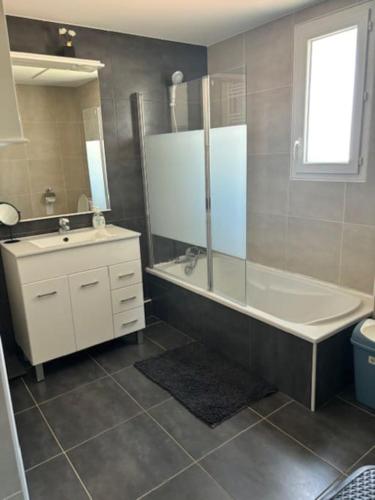 une salle de bain avec une baignoire, un lavabo et des toilettes dans l'établissement Villa avec jacuzzi - 3 chambres, à Béziers